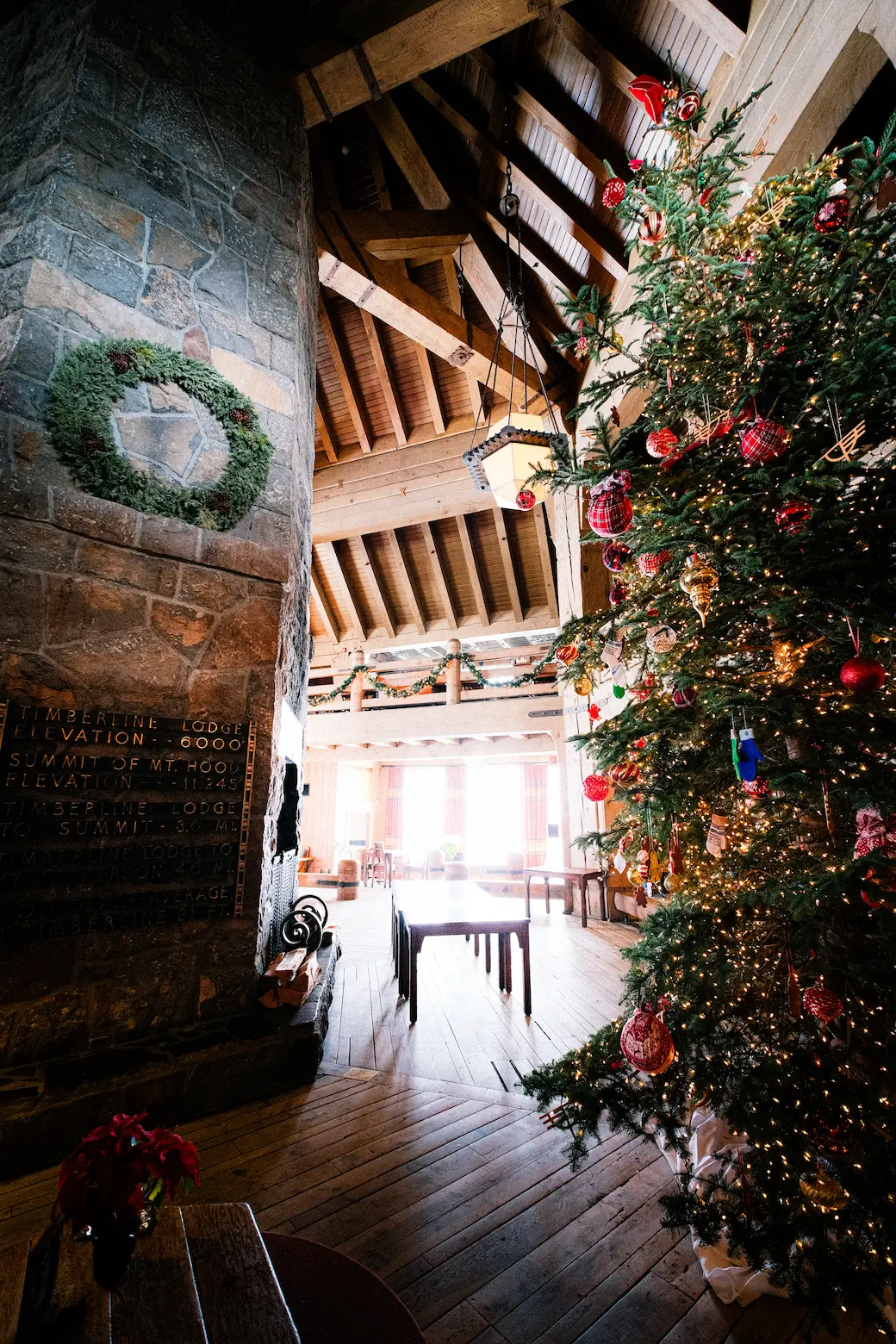 Large holiday tree with lights and decorations inside the headhouse at Timberline Lodge