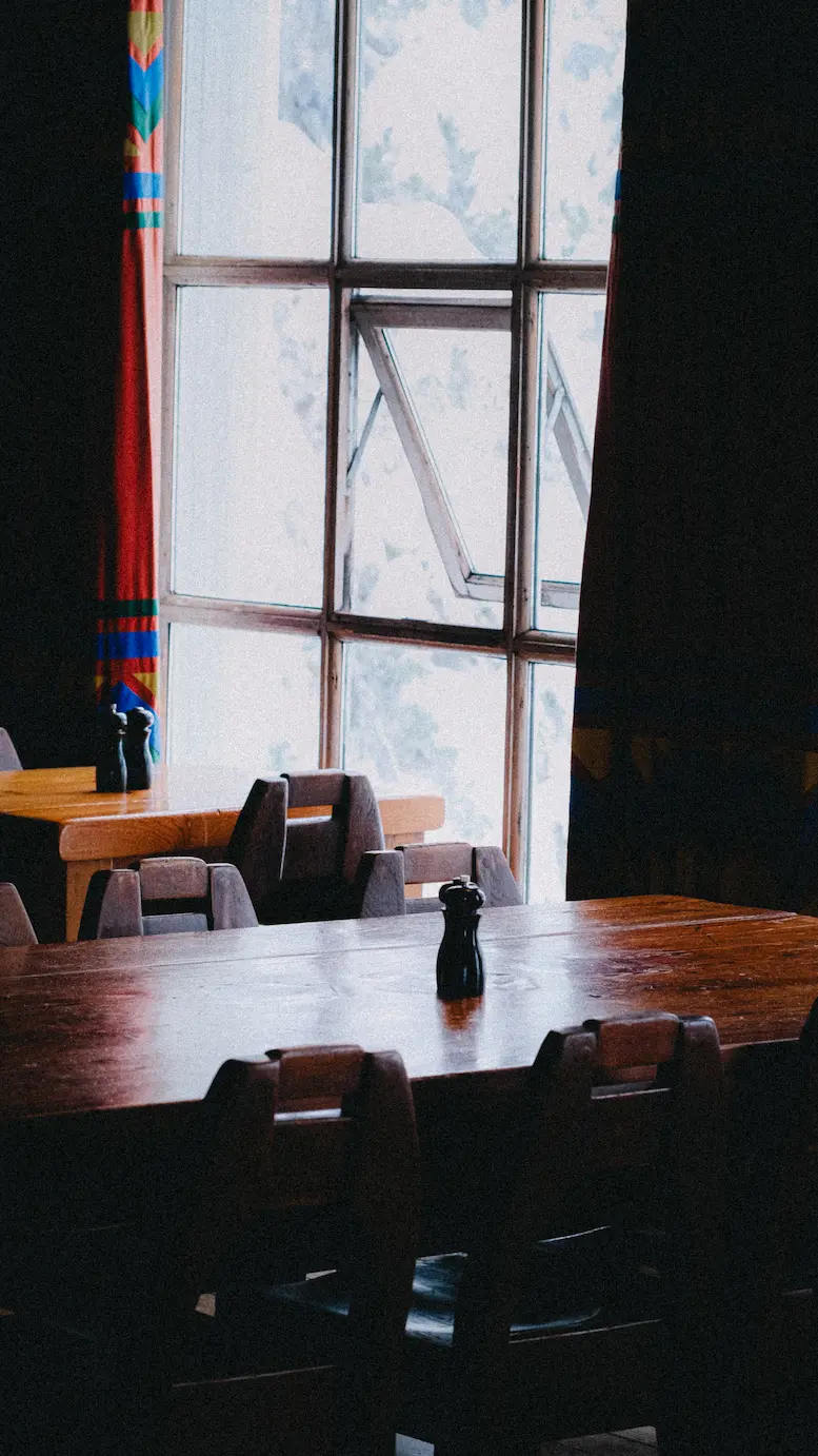 Wooden tables at a restaurant, with snow through the window