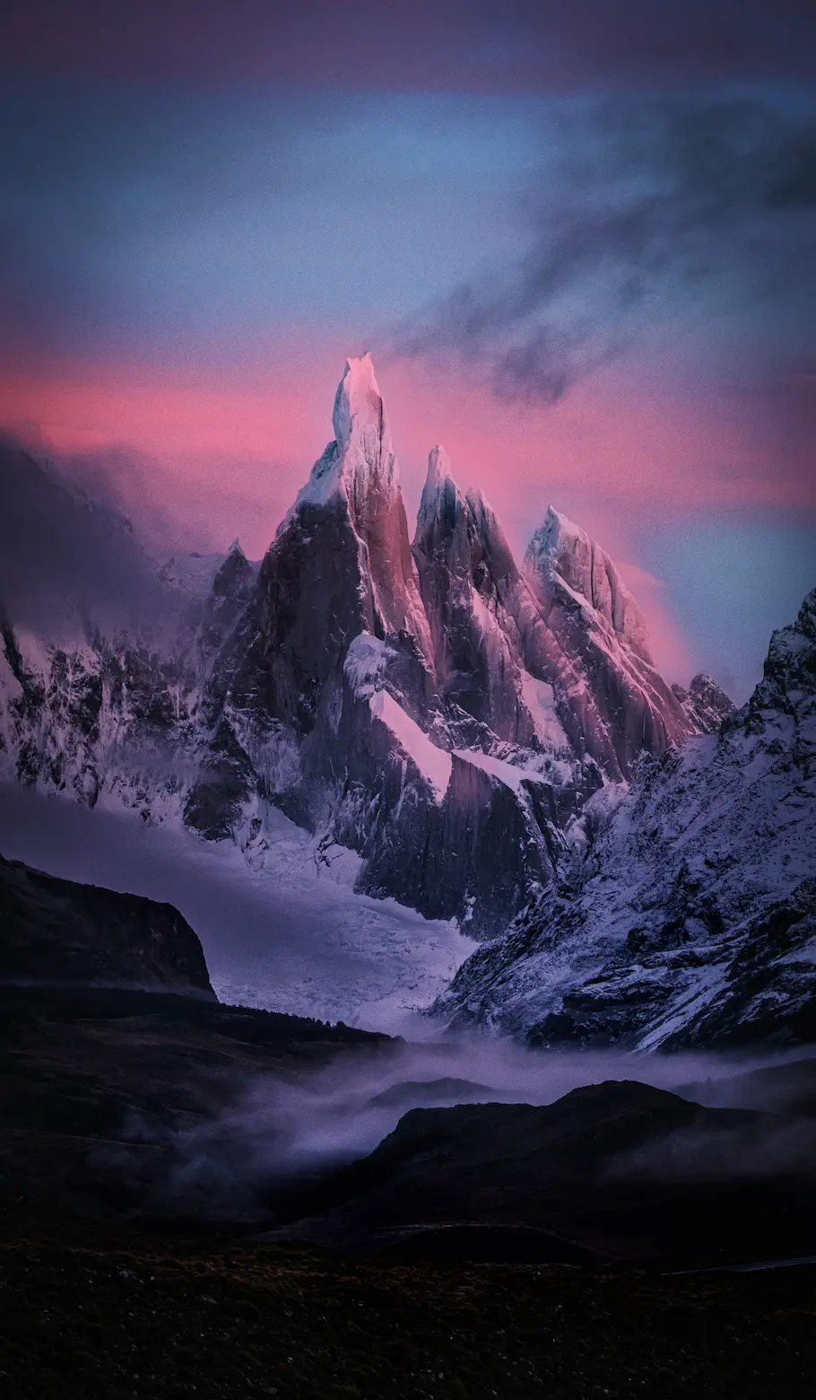 Sunrise at Cerro Torre, a mountain group in Patagonia. Pink and Blue colors light up the peaks.