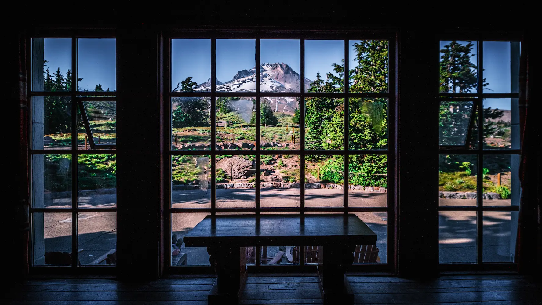 View of a mountain in the summer from inside a lodge