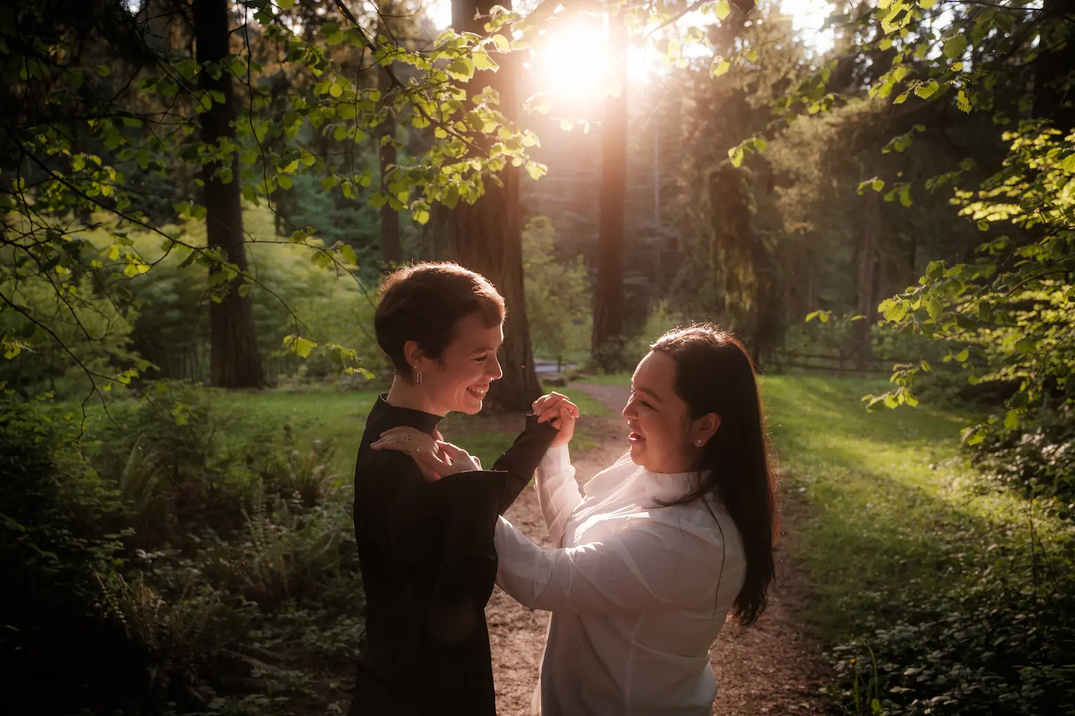 Couple dancing in the forest with sun in the background