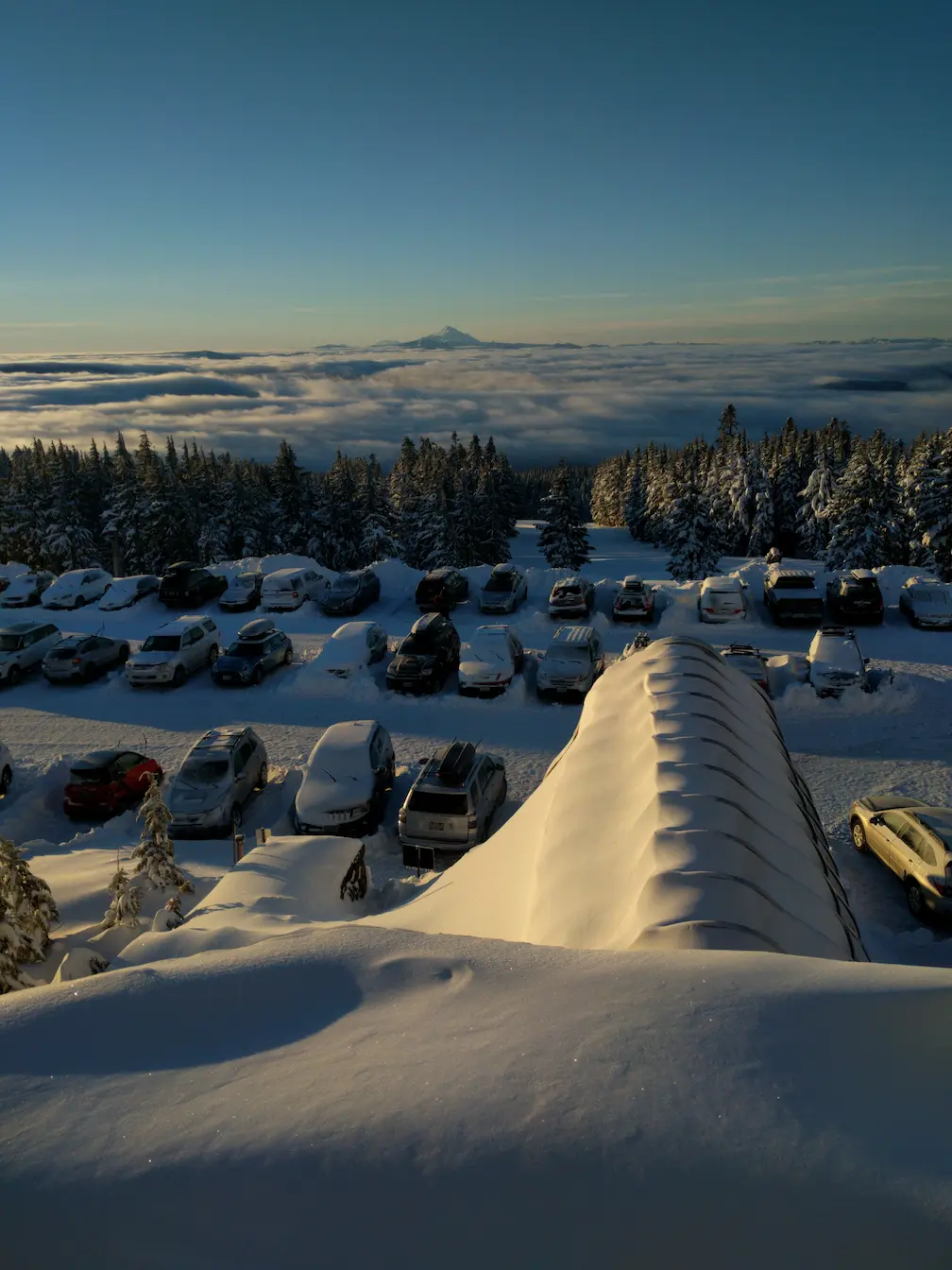 Parking lot of cars in front of Timberline lodge with view of the valley and Mt. Jefferson